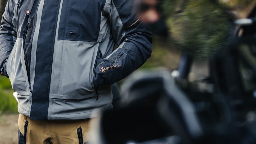 Man in a grey, blue Ranger ADV jacket with his hand in pockets.