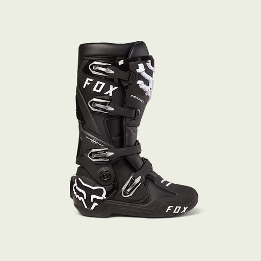 Black motocross boot on green background